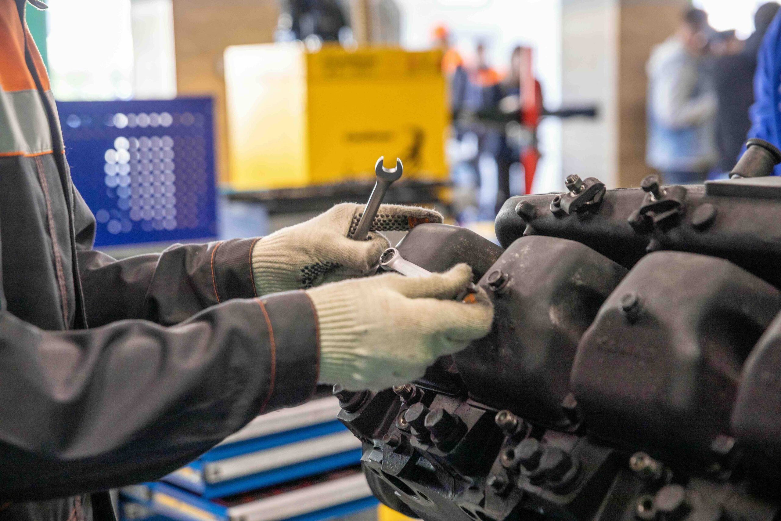 Mechanic working on large engine with a wrench in hand.